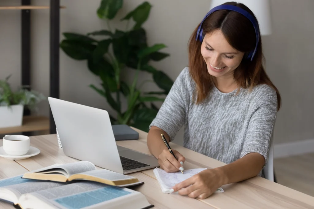 Woman studying at desk with laptop.