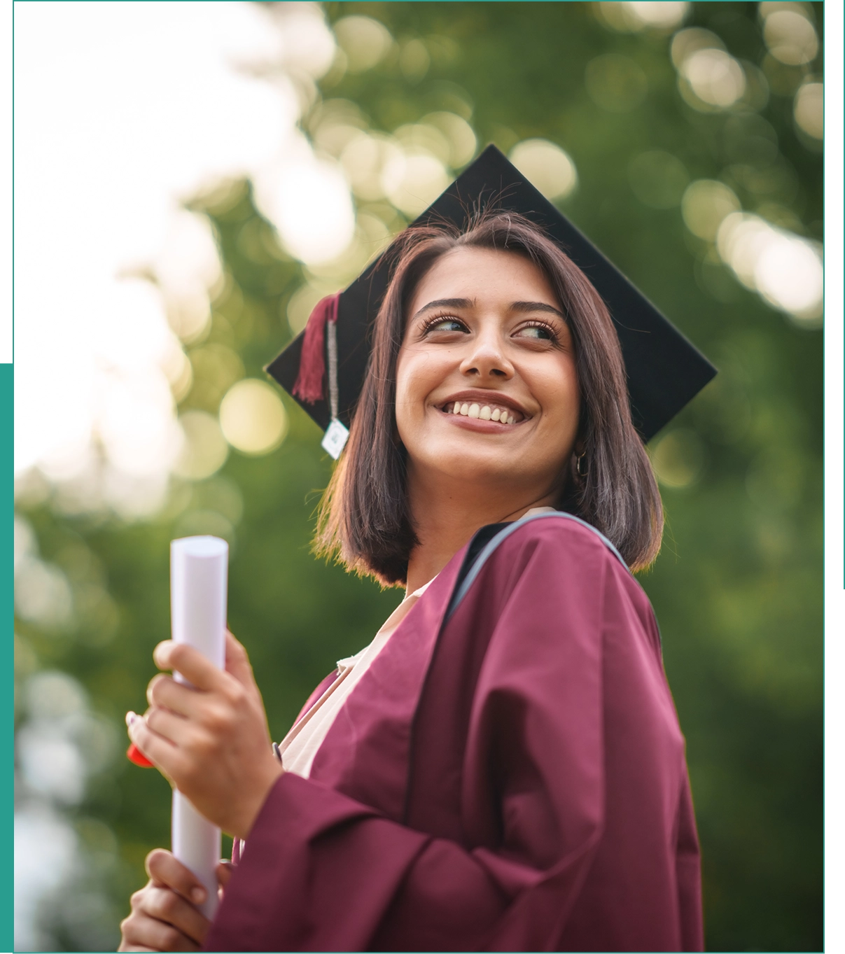Graduate wearing cap and gown, holding diploma.