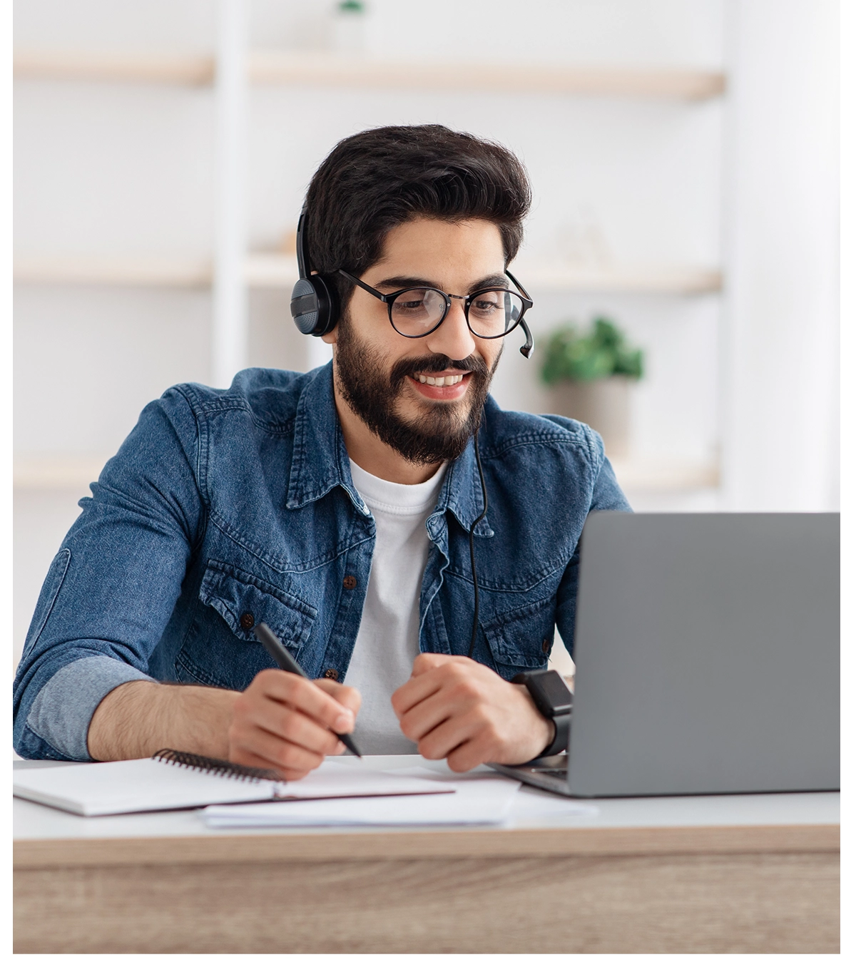 Man with headphones working on laptop.